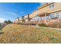 Row of tan townhomes with decks and a grassy area at 9752 Dahlia Ln, Thornton, CO 80229