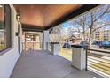 Inviting covered front porch featuring modern railings, painted brick columns, and wood ceiling at 1317 Monroe St, Denver, CO 80206