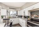 Well-appointed kitchen with stainless steel appliances, gray countertops, and white cabinetry at 4685 Wadsworth Blvd, Wheat Ridge, CO 80033