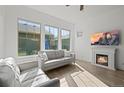 Bright living room with large windows, a cozy fireplace, and comfortable seating, perfect for relaxation at 5074 Yosemite Ct # 1, Denver, CO 80238
