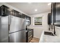 This kitchen boasts stainless steel appliances, black cabinets, and a large window over the sink at 8035 W Eastman Pl # 106, Lakewood, CO 80227