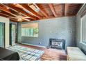 Living room with wood plank ceiling, brick accent wall and wood burning stove fireplace at 4365 Kendall St, Wheat Ridge, CO 80033