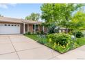 Attractive home featuring a well-kept lawn and vibrant flowerbeds at 2112 S Olathe St, Aurora, CO 80013