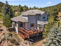 Two-story house boasts a spacious deck, manicured landscaping and surrounded by mature trees at 31518 Niakwa Rd, Evergreen, CO 80439