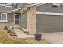 Front entrance with a walkway leading to a red door and an attached garage at 10491 Tiger Run, Lone Tree, CO 80124