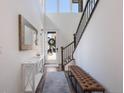 Bright foyer features high ceilings, a console table, a tufted bench, and staircase at 15624 W Floyd Dr, Morrison, CO 80465