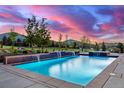 Beautiful swimming pool at sunset offers a tranquil escape with picturesque views of the rolling countryside at 5727 Colorow Dr, Morrison, CO 80465