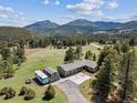 Aerial view of a home, garage, camper, and mountains in the background at 30651 Hollings Way, Golden, CO 80403