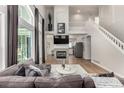 Bright living room with tall windows, fireplace, hardwood floors, and modern decor at 10765 Fremont Dr, Parker, CO 80134