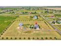 Aerial view showcases a large property with a home, barn, and surrounding landscape at 56920 E 42Nd Ct, Strasburg, CO 80136