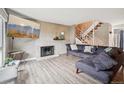 Spacious living room features a brick fireplace, modern furnishings, and a view of the staircase at 6376 E Mississippi Ave, Denver, CO 80224