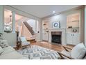 Cozy living room with a fireplace, built-in shelves, hardwood flooring, and a staircase view at 222 S Monroe St, Denver, CO 80209