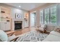 Bright living room featuring hardwood floors, a fireplace with built-ins, and plantation shutters at 222 S Monroe St, Denver, CO 80209