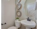 Stylish powder room with decorative wall baskets, oval mirror, and a pedestal sink at 1218 Sugarloaf Ln, Erie, CO 80516