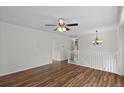 Spacious room featuring wood-look floors, white walls, ceiling fan, and staircase access at 11823 Steele St, Thornton, CO 80233
