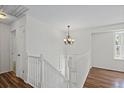 Bright foyer showcasing white banister staircase, chandelier, and wood-look flooring at 11823 Steele St, Thornton, CO 80233
