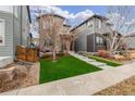 Lovely two-story home with landscaped front yard, concrete walkway, and modern architectural design at 6777 Larsh Dr, Denver, CO 80221