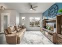 Comfortable living room featuring stylish furnishings, a media center with fireplace, and large window at 6777 Larsh Dr, Denver, CO 80221