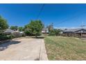 Spacious backyard with a concrete patio area and grassy lawn, offering ample outdoor space and a chain-link fence at 7111 Clermont St, Commerce City, CO 80022
