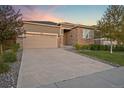 Charming home exterior featuring a two-car garage, brick accents and a well manicured front yard at 452 S Norfolk Ct, Aurora, CO 80017