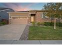 Charming home exterior featuring a two-car garage, brick accents and a well manicured front yard at 452 S Norfolk Ct, Aurora, CO 80017