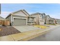 Street view of single-Gathering homes with well-manicured lawns, attached garages, and a sidewalk at 239 Chipeta Way, Lochbuie, CO 80603