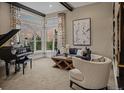 Bright living room with large windows, a piano, and comfortable seating arrangements at 10826 Evergold Way, Highlands Ranch, CO 80126