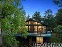 Modern home exterior with large windows and a charming wooded setting at 21859 Grandview Ave, Golden, CO 80401