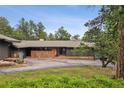 Ranch style home with a stone facade and mature landscaping at 21859 Grandview Ave, Golden, CO 80401