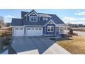 Charming craftsman-style home with a three-car garage, a well-manicured lawn, and covered porch at 885 Delechant Dr, Erie, CO 80516