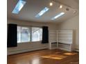 Living room with natural light, hardwood floors, built-in shelving, and track lighting at 2045 S Monroe St, Denver, CO 80210