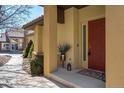 Inviting front porch with a red door, decorative plant, and neutral-colored accents, offering a welcoming entrance at 4648 S Abilene Cir, Aurora, CO 80015