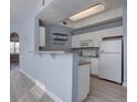 Cozy kitchen featuring white appliances, light blue paint, and a peninsula at 12914 Ironstone Way # 201, Parker, CO 80134