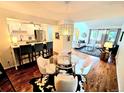 Open concept living space, including a kitchen with a bar, round table and chairs, and adjacent living room at 1073 W Powers Ave, Littleton, CO 80120