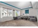 Cozy living room with a large sectional sofa, neutral carpet and bright natural light at 20031 Elgin Dr, Denver, CO 80249