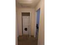 Hallway laundry closet featuring a stacked washer and dryer and bi-fold doors at 2793 Roslyn St, Denver, CO 80238