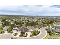 Expansive aerial view of a residential community with well-maintained lawns, mature trees, and mountain views at 2115 Holmby Ct, Castle Rock, CO 80104