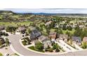 Aerial shot of luxury homes with landscaping and winding roads surrounded by rolling hills and scenic views at 2115 Holmby Ct, Castle Rock, CO 80104