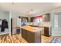 Modern kitchen featuring stainless steel appliances, a kitchen island, and light wood flooring at 2175 E 126Th Way, Thornton, CO 80241