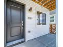 Attractive black front door with visible house number and modern outdoor lighting fixture at 13625 E 103Rd Pl, Commerce City, CO 80022