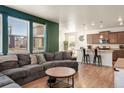 Open-concept living space with a sectional sofa adjacent to the kitchen, perfect for entertaining at 45810 Laceleaf Dr, Bennett, CO 80102