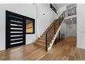 Light and airy entryway with hardwood floors and a modern staircase at 8077 Raphael Ln, Littleton, CO 80125