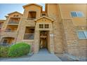 Close-up of the condo entrance featuring stone accents, stairs, and unit number signs at 17497 Nature Walk Trl # 302, Parker, CO 80134