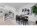 Bright dining room features modern lighting, wood floors, and a staircase at 12054 E 3Rd Ave, Aurora, CO 80011