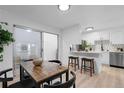 Bright dining room features a wood table, bar seating and access to the kitchen at 12054 E 3Rd Ave, Aurora, CO 80011