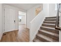 Bright foyer with hardwood floors, a staircase leading upstairs, and a view into the living area at 9081 Telluride Ct, Commerce City, CO 80022