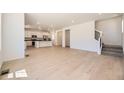Open-concept living space featuring wood-style floors, a staircase, and a seamless transition to the kitchen at 662 N Clubview St, Watkins, CO 80137