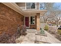 Close up of front door and entry showcasing brickwork and landscaped walkway at 1571 S Trenton Ct, Denver, CO 80231