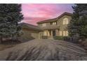 Two-story home with a large driveway and beautiful sunset at 2457 S Xenon Way, Denver, CO 80228