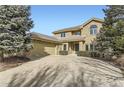 Two-story brick home with a large driveway and mature trees at 2457 S Xenon Way, Denver, CO 80228